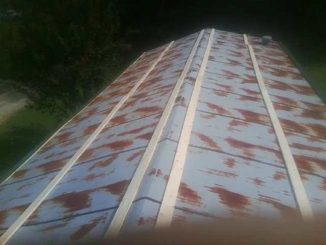 Rusted metal roof panels with new wood purlins before replacement — Storm Damage Roof Repair in Hasty by Roofing Brothers